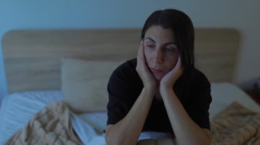 Gecenin sarmaladığı genç bir kadın, yatağında tek başına oturuyor. Yüzündeki ifade derin bir üzüntüden, yalnızlıktan ve depresyon ve uykusuzlukla olan sessiz mücadeleden bahsediyor..