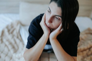 Genç bir kadın loş ışıklı odasında oturuyor, düşüncelerinde kayboluyor. Geceleri uykusunu kaçıran yalnızlık ve depresyonla yüzleşirken yüzü hüzün dolu..