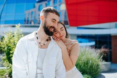 Sevgi dolu bir çift, kadın ve erkek, sevgiyle kucaklaşıyorlar. Açık havada gülümseyen bir çiftin Sevgi Portresi