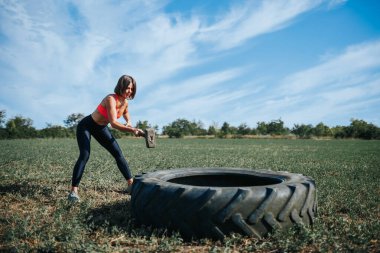 Crossfit Oturumu Güçlü Kadın Kuvvetli Egzersiz Yapıyor, Balyozla Lastiğe Vuruyor. Kuvvet ve Dayanıklılık Kadın Sporcusu Çapraz Eğitimde Lastik Vuruşu Egzersizi Yapıyor