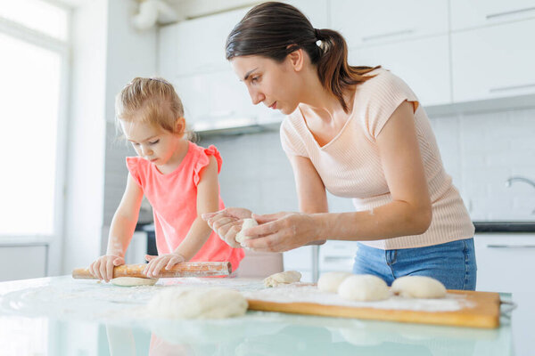 Кухня становится холстом для семейного сближения, так как мать и дочь готовят тесто, создавая шедевр, наполненный памятью. Связь приготовления пищи матери и дочерей Домашнее удовольствие от теста