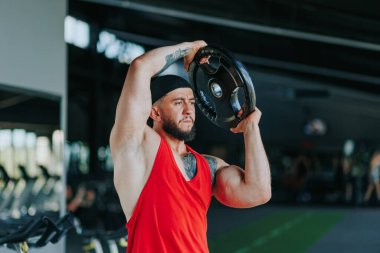 Bu güçlü atlet ağırlık kaldırma rutinine odaklanırken spor salonu ağırlık çırpma sesiyle yankılanıyor. Güçlü Kaldırma Spor Salonu Halter Oturumunu Destekliyor