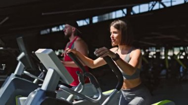 Hem erkek hem de kadın sporcular da dahil olmak üzere kapalı spor salonundaki enerjik bir grup çalışmasına katılıp sağlıklı bir yaşam tarzının faydalarını destekliyorlar..