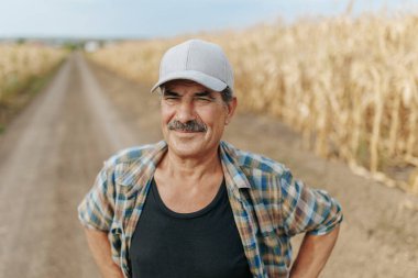 An elderly farmer with a mustache, captured in a portrait on his agricultural land, representing the timeless dedication to farming and rural life.