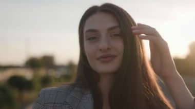 Gün batımında açık havada, doğal güzelliği ve zarafetiyle genç esmer bir kadının sakin bir portresi..