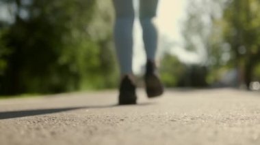 Koşu yaparken kadın bacaklarının yakın plan çekimleri kaldırıma karşı koşu ayakkabılarının hareketini vurguluyor. Bulanık arkaplan bulanık bir hız ve eylem hissi yaratır.