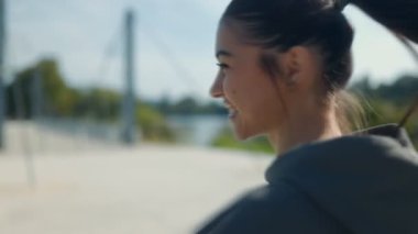 Genç, esmer bir kadın parktaki parlak ve güzel bir günde dışarı çıkıyor..