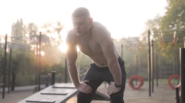  Erkek sporcu spor sahasında sıkı bir idmandan sonra nefes alıyor. 