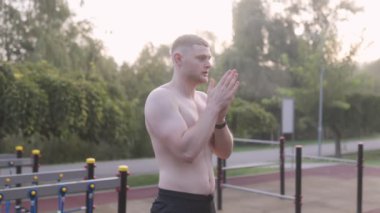  Erkek sporcu spor sahasında ellerini ovuşturuyor 