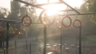  Erkek sporcu spor sahasında jimnastik halkaları kullanarak akrobatik jimnastik yapıyor. 