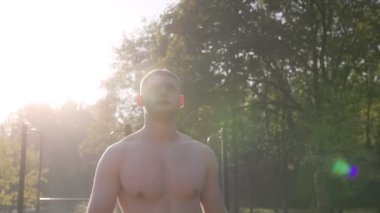  Erkek sporcu spor sahasında jimnastik halkaları kullanarak akrobatik jimnastik yapıyor. 