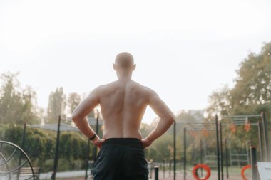 Üstsüz bir adamın yüksek yoğunluklu açık hava eğitimi alması fiziksel gücünü, dayanıklılığını ve kendini sağlıklı bir yaşam tarzına adamasını yansıtıyor..