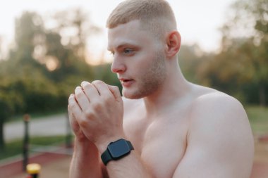 Atletik fiziği sergilenirken, bu zinde genç adam spor salonunda jimnastik yapmaya başlamadan önce düşüncelerini toparlamak için biraz zaman ayırıyor..