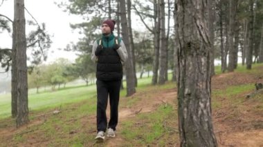 Huzurlu bir ormanda doğal ortamın ve temiz havanın tadını çıkaran bir adam. 