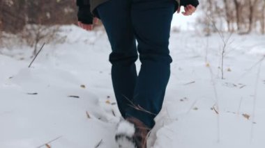 Donmuş Ayak İzleri Karlı yolda iz bırakan bir adamın samimi görüntüsü, Buzlu güzellikler arasında sakin bir kış yürüyüşünün özünü yakalıyor..