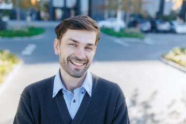 Bu portre gülen bir profesyoneli sonbahar renkleriyle çevrili bir şehir ortamında yakalıyor. Kendine güveni ve dostça tavırları samimiyet ve yakınlık gösteriyor..