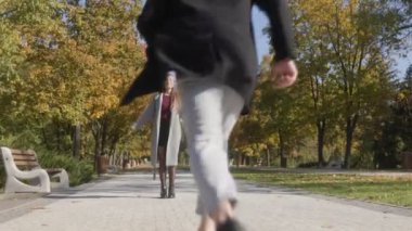 Çift, altın yapraklarla çevrili bir sonbahar parkında birbirine yakın duruyor. Mutlulukları somut, mevsimsel bir ortamda aşkın güzelliğini somutlaştırıyor..