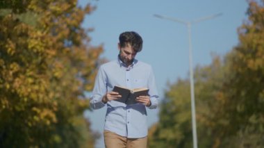 Amerikalı bir adam sakin bir park ortamında yürüyüp kitap okuyarak rahatlamanın tadını çıkarır. Kendini tamamen kitabına kaptırmış durumda. Doğanın basitliğinde huzur buluyor..