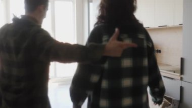 Bu iç açıcı sahnede, evlerinde kutularla dolu birkaç kucaklama. Heyecanlı adam, yeniliklerin manzarasını heyecanlı karısına gösteriyor, birlikte kutluyoruz..