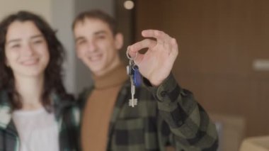 Bir çift, tadilat altındaki evlerinde kucaklaşıyor. Koca anahtarları elinde tutuyor, mutlu karısına yeni evlerini gezdiriyor, içi boş kutularla dolu..