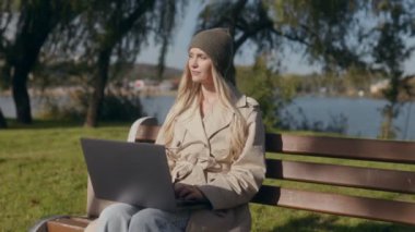 Doğada sakin bir çalışma anı. Genç bir kadın, sonbaharda parkta bir bankta otururken dizüstü bilgisayarına yazar. Kalın giyinmiş, mevsimi takdir ediyor..