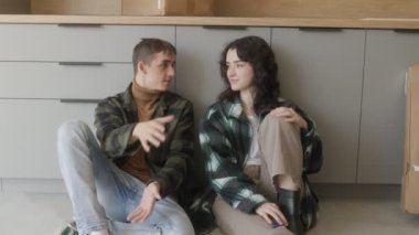 Karton kutuların ortasında, bir çift yerde oturup yeni dairelerinin yenileme sürecini tartışıyor. Rahatlar, odaklanırlar ve gelecek için heyecanlanırlar..