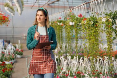 Kafkas kadın renk çiçeklerinin verilerini analiz etmek ve kaydetmek için serada deney yapmak için defter kullanıyor. Amerikan tarım mühendisi seradaki santralleri teftiş ediyor, uzayı kopyalıyor.