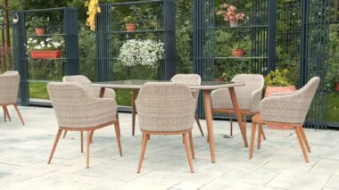 Veranda seti, masa ve sandalyeler. Sandalyeler hasırdan yapılmış ve masa ahşaptan yapılmış. Verandanın etrafında birkaç saksı bitkisi var, uzaya biraz yeşillik katıyor.