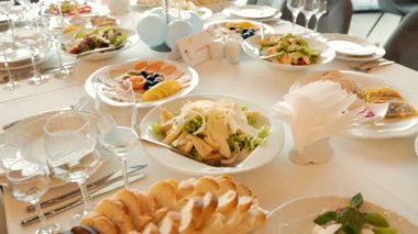 Masa, üzerinde mavi peçete olan yiyecek ve içeceklerle dolu. Masa bir parti ya da toplantı için hazırlandı.