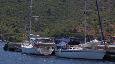 İki yelkenli bir marinaya yanaştı. Teknelerden birinin üzerinde mavi bir kapak var.