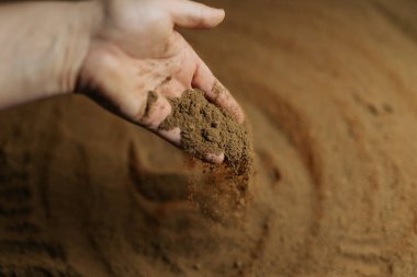 Ellerin toprağa ince toprak yaydığı ve yeryüzünde bir düzen oluşturduğu gösterilir. Bu faaliyet, bahçıvanlık ve ekimin yetiştirilme sürecini temsil etmektedir..