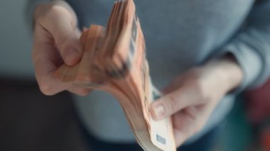 Avro banknotlarını sunan eller, Avrupa ekonomisi ve zenginlik yönetimi bağlamında mali başarı, gelir ve para güvenliğini sembolize etmektedir.