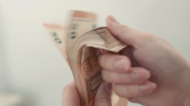Bir kişi, ayrıntılı ve sembolik bir sunumda refah, zenginlik ve parasal başarıyı yansıtan avro banknotlarının bir koleksiyonunu gösteriyor.