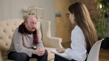 Terapist terapi seansı sırasında hastayı dikkatle dinler. Oda sakin, tartışma ve iyileşme için rahat bir ortam sağlıyor..