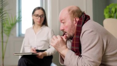 Terapist terapi seansı sırasında hastayı dikkatle dinler. Oda sakin, tartışma ve iyileşme için rahat bir ortam sağlıyor..