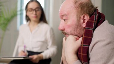 Terapist terapi seansı sırasında hastayı dikkatle dinler. Oda sakin, tartışma ve iyileşme için rahat bir ortam sağlıyor..