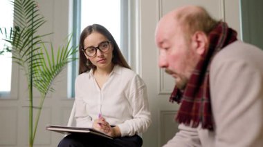 Terapist terapi seansı sırasında hastayı dikkatle dinler. Oda sakin, tartışma ve iyileşme için rahat bir ortam sağlıyor..