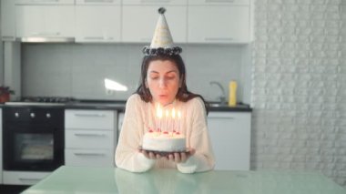 Mutfakta tek başına oturan bir kadın doğum gününü kutluyor. Bayramlık pastaya mum üfleyerek. Huzurlu ve düşünceli bir anın tadını çıkarıyor..