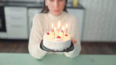 Doğum günü kutlaması. Masada tek başına oturan bir kadın. Bir dilek diliyor ve ev ortamında pastasına mum üflüyor..