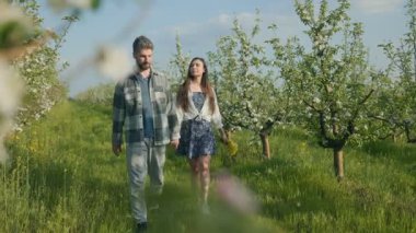 Genç bir çift, bahar güneşi altında el ele tutuşarak çiçek açmış muhteşem bir meyve bahçesinde yürüyor. Aşk ve doğa birlikte mükemmel bir huzur ortamı yaratır..