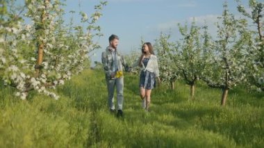 Çiftler güneşli bir günde çiçek açan bir meyve bahçesinde tatlı bir yürüyüşü paylaşırlar. Yeşil çimenler ve çiçeklerle çevrili, aşktan, kahkahadan ve temiz havadan hoşlanırlar..