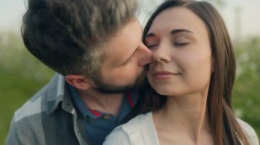 Çiçek açan ağaçların arasında dikilen iki genç sevgili arasında samimi bir kucaklaşma, günışığı, sıcaklık ve gerçek bağlarla dolu zamansız bir bahar romantizmini yakalıyorlar..