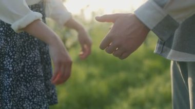 Huzurlu bir alanda el ele tutuşarak birbirine bağlanan iki insan. Sıcak güneş ışığı sahneyi yıkıyor ve öğleden sonra romantik bir atmosfer yaratıyor..