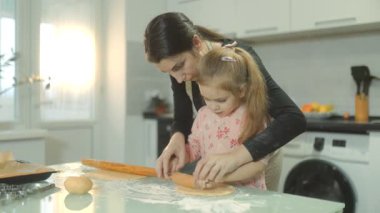 Bir anne kızına taze hamur sarmayı öğretirken sıcak bir ev mutfağında lezzetli kurabiyeler hazırlarken yürek ısıtan bir aile aktivitesi başlıyor..
