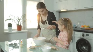 Evde lezzetli ev yapımı bisküviler için hamuru karıştıran anne ve kız arasında mutfak ekibi çalışması..