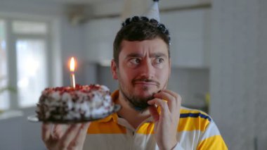 Yalnız ama mutlu bir adam evde doğum gününü mumları üfleyerek ve duygusal ve şenlikli bir mutfak sahnesinde dilek tutarak kutlar..