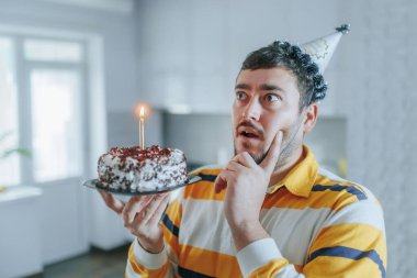 Duygusal ve düşünceli, orta yaşlı sakallı bir adam doğum gününü yalnız kutluyor, elinde mumlarla bir pasta tutuyor, evindeki mutfağın sıcaklığında içten bir dilek diliyor..
