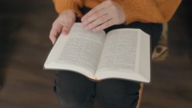 İnancını yansıtan, elinde İncil tutan bir kadının yakın plan görüntüsü. Bu sessiz ve odaklanmış an kişisel maneviyatın ve bağlılığın göstergesidir..