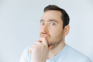 Genç bir adam derin düşüncelere dalmış, çenesini elinde dinlendiriyordu. Açık renkli, basit bir arka planla çevrili, tuhaf bir ifadeyle yan tarafa bakıyor..