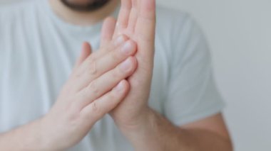 Bir insan sürmeden önce ellerini kremi birbirine sürtmek için kullanır. Etkinlik, kapalı alanda parlak ve temiz bir ortamda kişisel cilt bakımını vurguluyor..